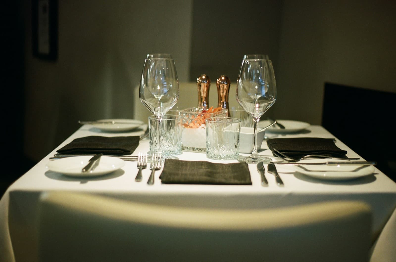 Butler laying a formal table setting in a grand private dining room